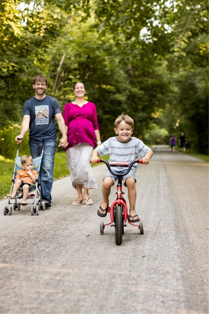 A family biking together on the paved trail near the cabins